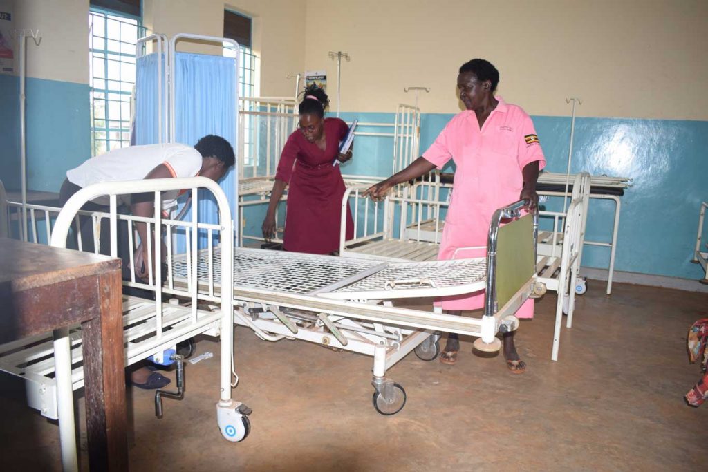 IDIWA Staff being shown an adjustable bed in the labour     ward by midwife Mbulamuti HC III 